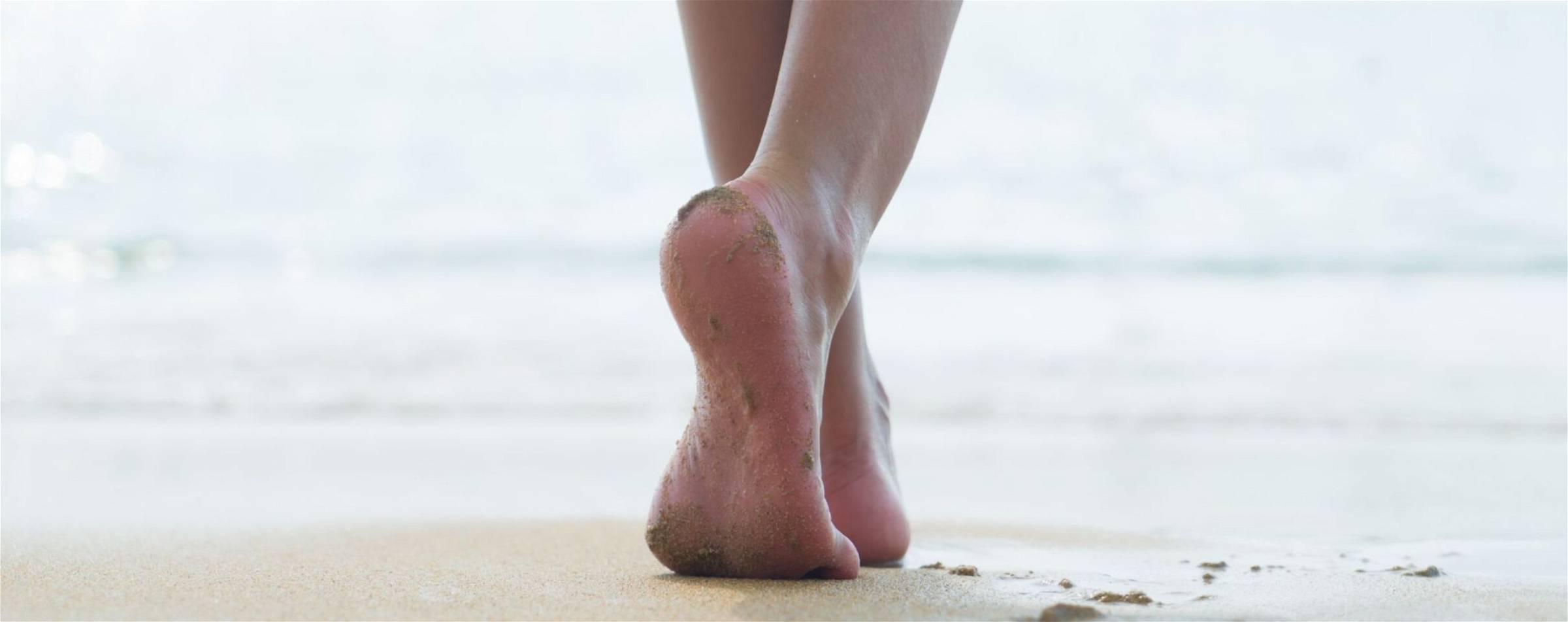 Blote voeten over het strand als detox.
