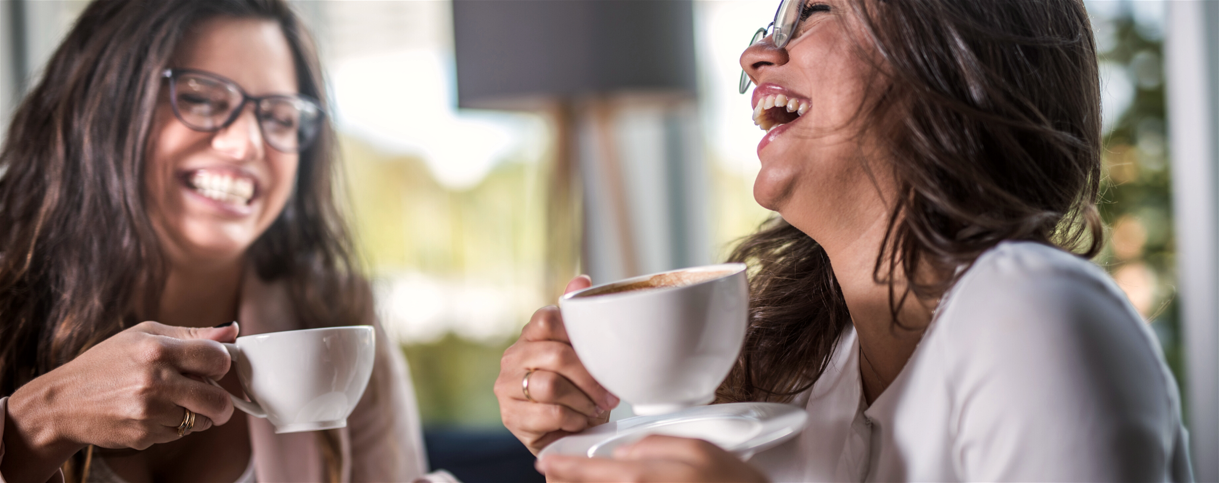 Lachende vrouwen met een lekkere kop koffie.